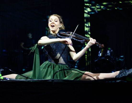 Lindsey Stirling in Stockholm, playing the violin while doing the full split